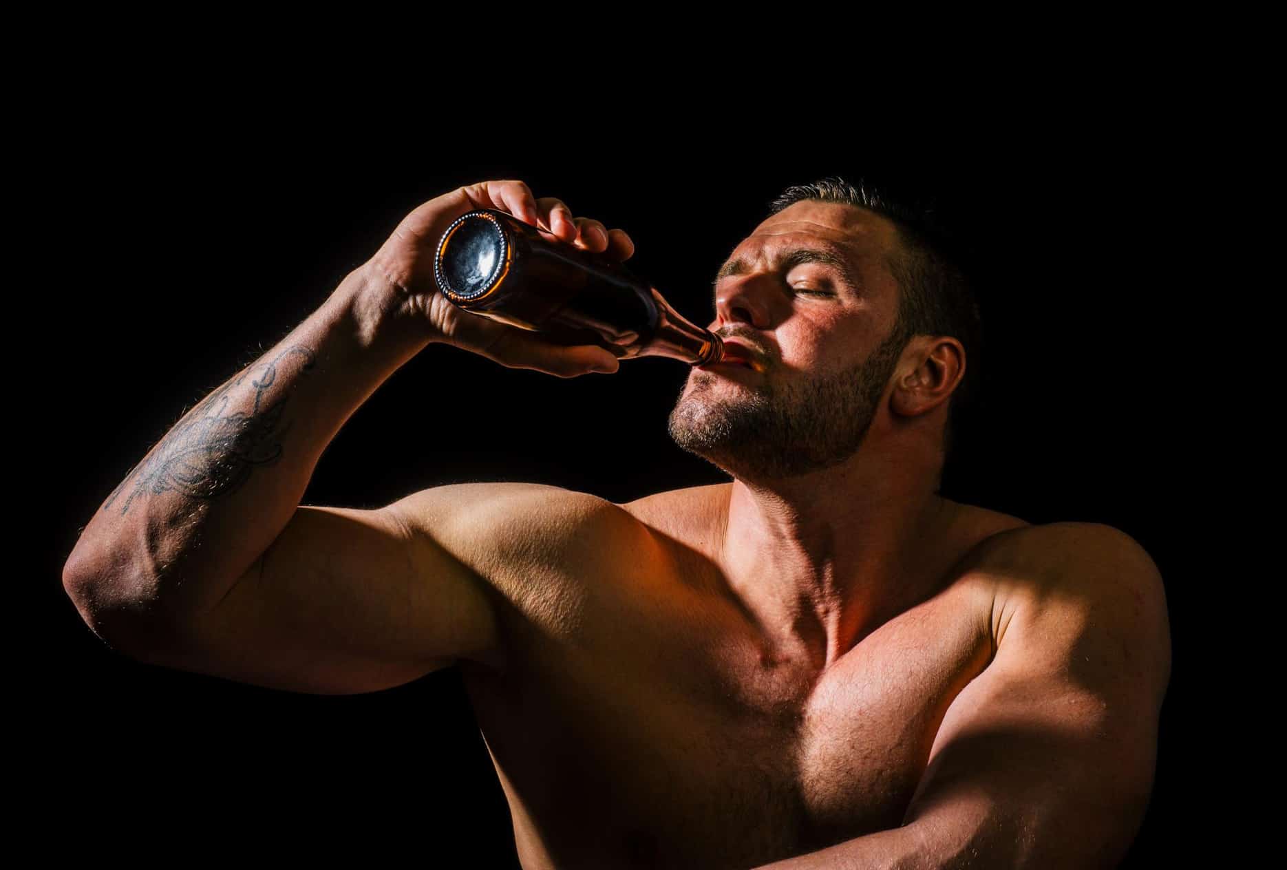 Muscular man drinking beer